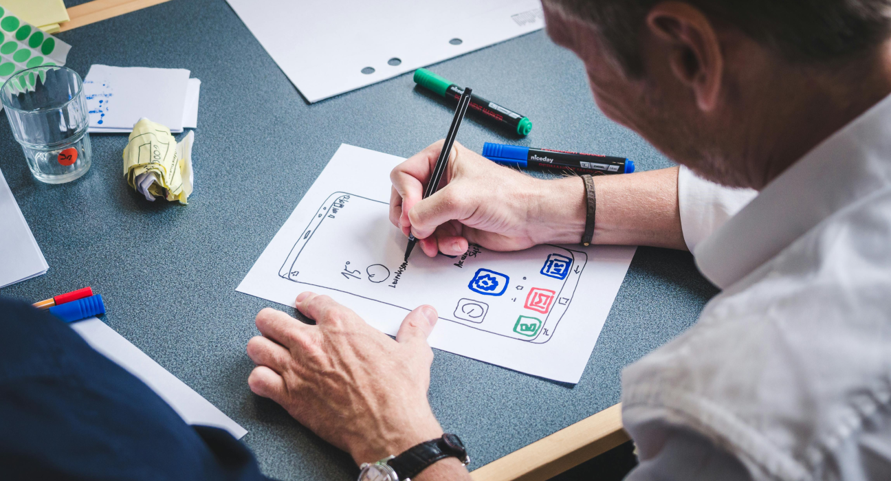 Person engaged in UI/UX design process, brainstorming and sketching ideas.